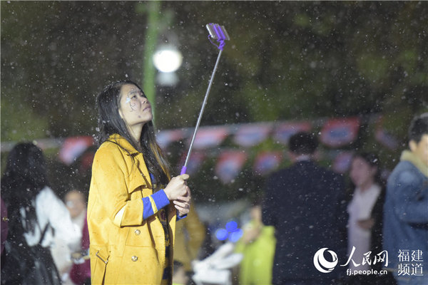 游客在“大雪纷飞”的景致中拍照留影。沈宇波 摄