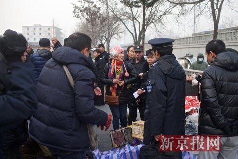 警方联合城管正查扣路边摊位售卖物品。新京报记者 周岗峰 摄