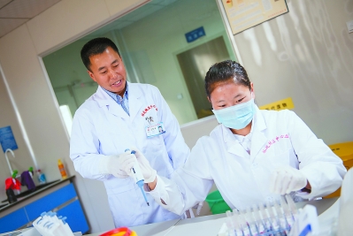 ?林芝市中心血站副站长涂东晋与藏族同事在一起工作。