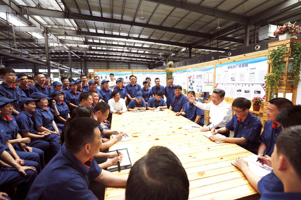 图为:2015年7月17日,习近平在吉林东北工业集团长春一东离合器股份有限公司的车间班组园地同职工座谈。