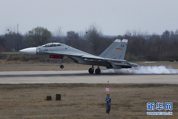 2015年3月4日,“海空雄鹰团”的一家战机着落的瞬间,轮胎和跑道发生着剧烈的摩擦。新华社记者琚振华摄