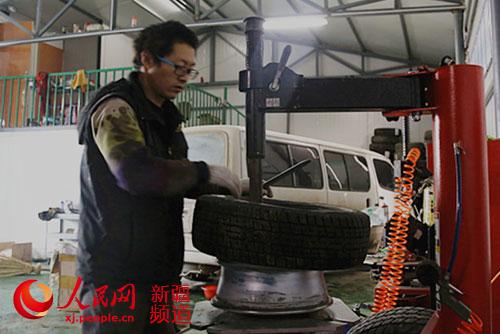 修理工杨彦平在拆装轮胎。(摄于2015年12月22日)