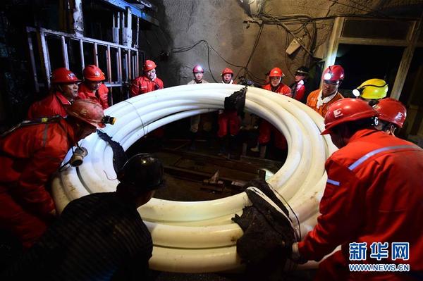 12月27日,救援人员在井下搬运抢险物资。