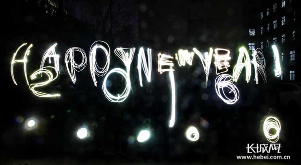 　　社区工作人员和大学生用光绘形式画出“happy new year”和“2016”。