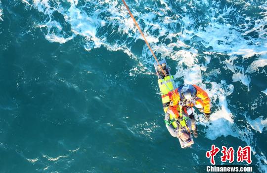 图为救援人员吊起受伤渔民。　曹煜　摄