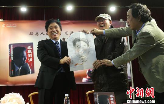 漫画家（中）为刘洪（左）送来一幅刘洪漫画，右为作者梁平。　泱波　摄