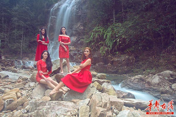 青山绿水间，一袭红装的模特更显娇艳。
