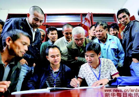 ▲在广西融安县大坡乡岗伟村平土屯,工作队员在向当地群众介绍“精准识别”。摄影:黄孝邦