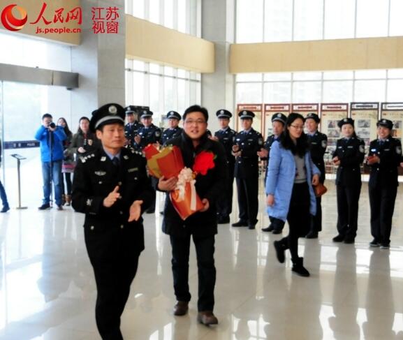 民警张洪波在同事们的掌声中接过鲜花