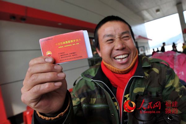 拿到“中国石油温馨返乡油卡”的农民工笑了