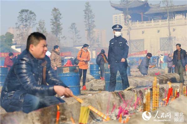 寺内进香广场上一位执勤民警正在巡视，提醒香客注意火烛