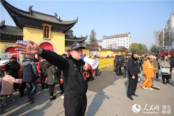 归元寺门前民警用小喇叭引导人流有序入寺