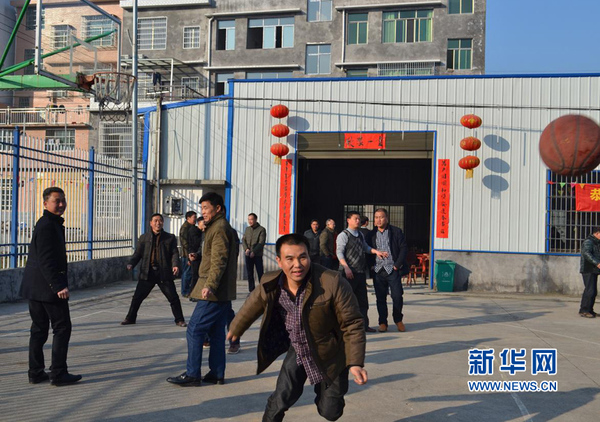 村民在旁边运动场为团拜后即将到来的篮球赛热身。新华网 吴丽娜 摄