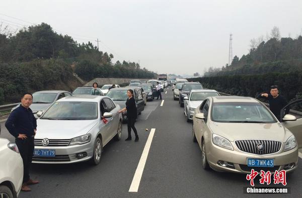 2月12日，京港澳高速岳阳至长沙段出现拥堵，乘客下车休息。当日是中国农历正月初五，全国多处高速路段迎春节长假返程高峰。中新社记者 刘关关 摄