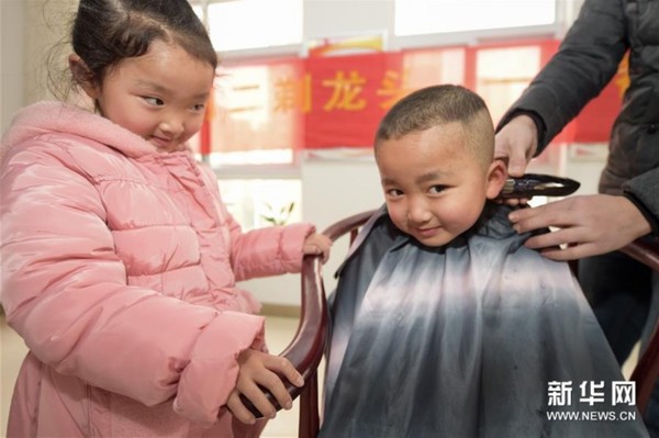 3月10日,志愿者在合肥市滨湖欣园社区为6岁半的龙凤胎王福安(右)和王欣萍免费理发。