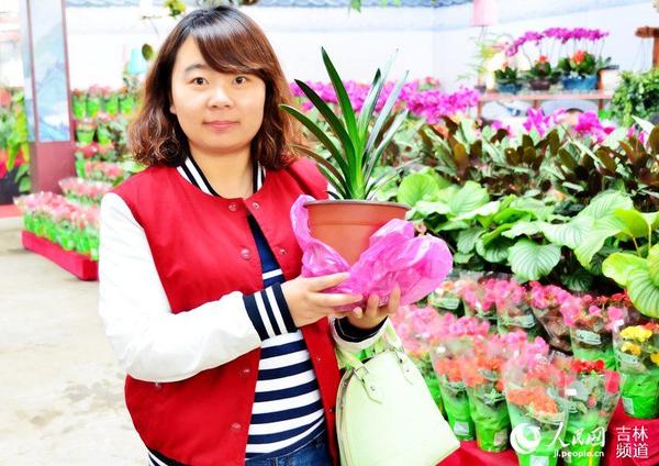 3月17日，张女士买到自己喜欢的君子兰，开心来展示。王帝元 摄
