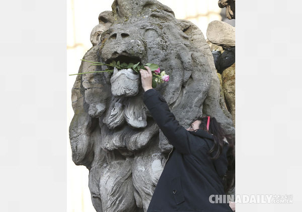 当地时间3月22日，一名女子以玫瑰花悼念布鲁塞尔爆炸案遇难者。（图片来源：路透社）