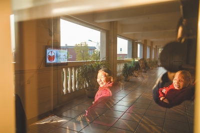 晋江磁灶大埔村的免费养老院里，老人们在夕阳下的活动室里看电视。在晋江，企业家和事业有成的年轻人回馈乡里，建立起服务老弱的机构和组织很常见。