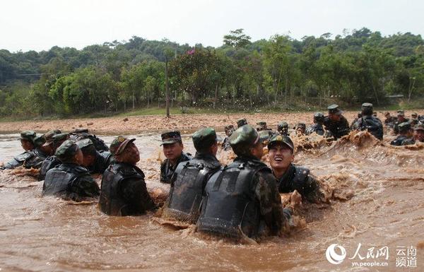 水中扛圆木。（摄影：董福星）
