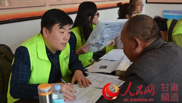 大爱清尘基金甘肃工作区志愿者在村委会登记求助者信息。