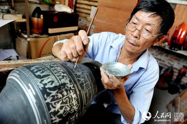 国家级“非遗”传承人李波生正在给脱胎漆器绘制图案。