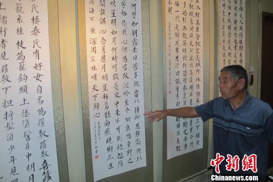 图为成安县70岁农民书法家吴珍为大家介绍自己的作品　庞帅　摄