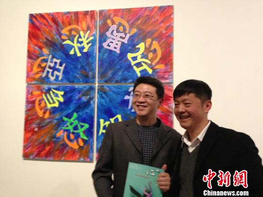 图为新媒体艺术家皮明（右）向友人介绍作品。　许婧　摄
