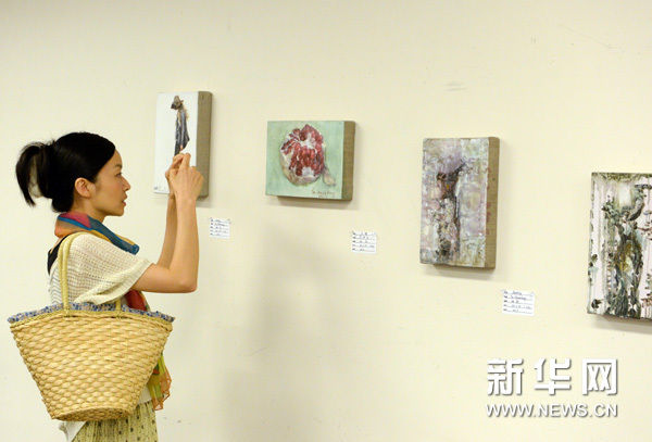 7月2日，在日本东京中国文化中心，一名参观者为展品拍照。新华网图片 马平 摄