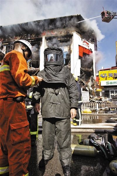 昨日，消防战士穿着隔热服装准备进入商场灭火。