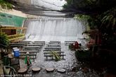 在位于菲律宾吕宋岛南部的旅游胜地埃斯库德罗庄园里，有一家奇特的瀑布餐厅，这间餐厅除了拥有漂亮的风景之外，最特别的地方就是餐厅竟然位于一条瀑布之下。该餐厅建于一个人工水坝之下，餐馆中的桌子、凳子等均放在瀑布流经的地方，因此人们在用餐的过程中会一直感受到潺潺的流水从脚下经过，让人有一种更加贴近大自然的感觉。