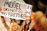 当地时间2012年2月24日，意大利米兰，米兰2012秋冬时装周，Versace秀场外被一群激进的女权主义组织所包围。情绪激动的女组员们纷纷真空上围大露点，高举着“模特们别进妓院”的招牌大闹Versace秀场。旋即引来警察的暴力管制。场面相当混乱。