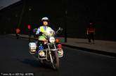 西安，“研究生女交警”高扬骑着摩托车在城墙根巡逻。