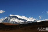 纳木那尼峰，藏民称之为“圣母之山”或“神女峰”。海拔7694米，位于喜马拉雅山西段，与海拔6638米的神山冈仁波齐峰遥遥相对。纳木那尼峰方圆约200平方公里，主要有6条山脊。山脊线上有数十座6000米以上的山头，高低错落。西面的山脊呈扇状由北向南排列，东面唯一的山脊被侵蚀成刃脊，十分陡峭，形成了高差近2000米的峭壁。相比而言，西面的坡度则较为和缓，峡谷间倾泻着五条巨大的冰川，冰面上布满了冰裂缝和冰陡崖。（图片来源：凤凰网华人佛教  摄影：湘江岸边）
