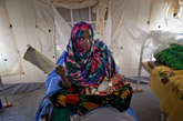 当地时间2012年4月18日，N'Gouri 一个闷热的重症监护篷内，Fatime在给8岁的女儿Kouboura Ali扇风。由于营养不良导致的疾病使Kouboura Ali无法经口进食。

