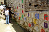 东巴文化就源于东巴教，至今已成为中华民族珍贵的文化遗产。东巴文共有单字1300多个，是一种原始的图画象形文字。图为游客在欣赏墙上的象形文字。