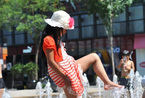 中国多地气温飙升 市民“轻装”遛街儿童嬉水觅凉 