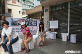 参与活动的女志愿者们在市城管委对开的路边摆起了“自带厕所”，抗议广州市公厕厕位男女比例失调。