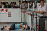 7月31日，上海，一名男子用杂志遮挡光线在地铁站睡觉纳凉。