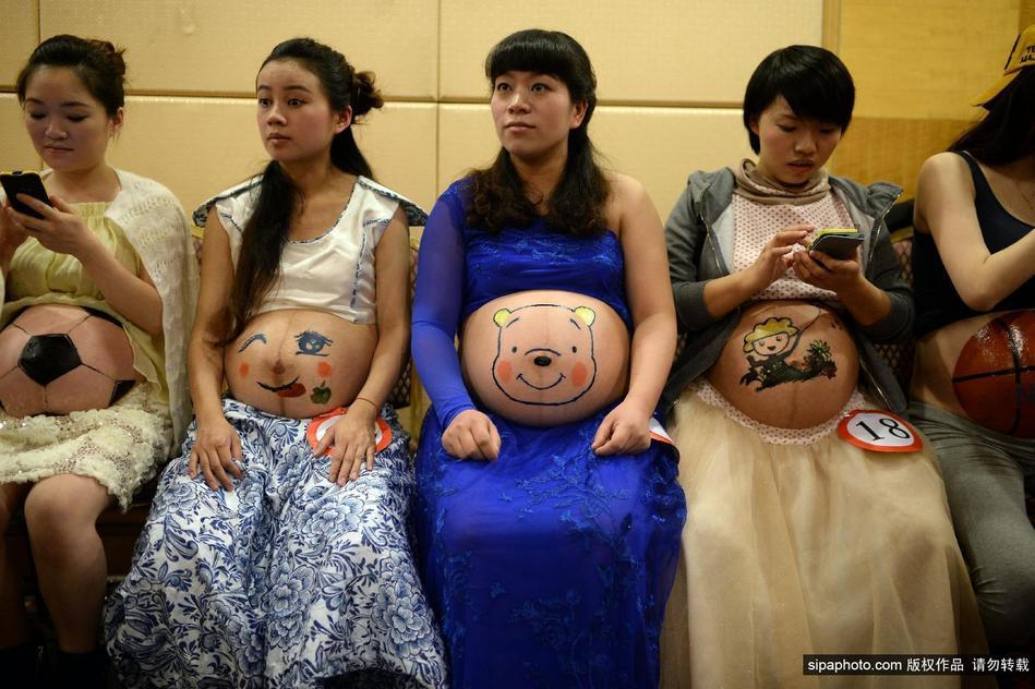 彩绘大赛.准妈妈们在自己挺起的肚子上绘画各种图案,代表着高清图片