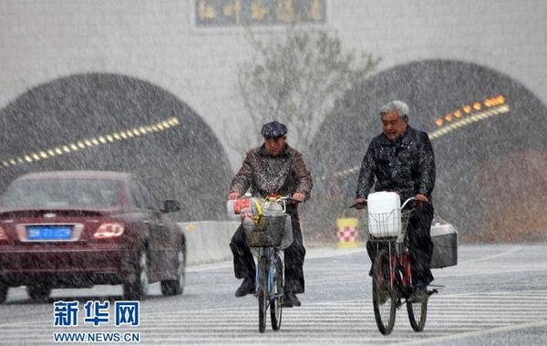 11月18日，在山东威海统一路，行人在雪中骑行。（于启波 摄） 新华网山东频道11月18日电 18日，受较强冷空气影响，山东威海迎来入冬后首场降雪，给人们出行带来不便。