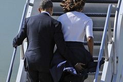 奥巴马用手捂米歇尔身体防风吹裙起