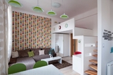 “舒适、活力”是这套32平公寓的设计主题。公寓空间局促，但包含了基本功能间，布局紧凑，少隔断，多开放，并利用白色放大空间感。卧室安排在二层的小区域，仅容下一张床，但却舒适无比，这也是小户型loft的常用设计。彩色叶子墙纸和翠绿色家具点缀其中，赋予小公寓活力与生机，备显清新。（实习编辑：温存）
