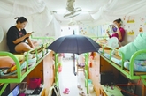 华中师范大学一女生寝室内，两位女生在电风扇的正下方放了把大伞，各自旁边也放了个小风扇，以享受到更多的凉爽。（实习编辑：温存）