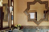 这一次，我们将讨论有关摩洛哥的浴室，让你感受水疗和精彩的休闲体验。那么如何达到这种效果呢？可以先从具有典型东方模式或混凝土墙壁、浴缸、瓷砖入手，之后是地毯，马赛克、陶瓷水槽和东方蜡烛的灯笼。浴室的颜色不要太亮，比如红色或蓝色，可以选择白色，浅灰色，蓝色或绿色。但是如果你想达到戏剧性的别致，那么选择蓝色、金色和黑色。适当添加木制家具，窗帘，瞧，你已经有了一个迷人的摩洛哥浴室了！