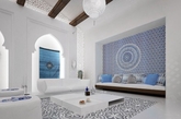 摩洛哥风格有着浓郁的地域风情，经典的古典建筑元素无疑是室内设计风格的重要表现手段。造型壁龛，经典花窗隔断都是不错的选择。地面也选择了比较有代表性的拼花图案。整个空间以白色为主，无论是吊顶、墙面、地面还是家具的选择都是以白色为主，只有少量的点缀采用了蓝色。让整个空间看起来纯洁素雅。(实习编辑：江冬妮）