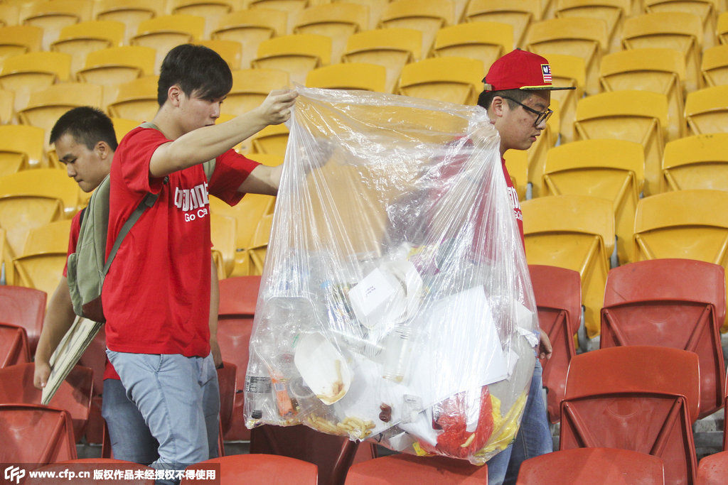 国足球迷赛场捡垃圾 球迷和球员同样赢得世界