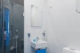 盥洗区墙面贴有白色的瓷砖，搭配白色的台面和台盆，用白色系为空间营造明亮洁净的感觉。而蓝色毛巾和洗浴用品的装饰，更让盥洗区显得干净清爽。镜柜的运用不仅提供了收纳装置，更是能够起到在视觉上拓展小空间的作用。（实习编辑：周芝）
