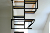 十八、多功能悬浮梯
受设计师Just Haastnoot的委托，Studio Mieke Meijer为他在荷兰瓦圣纳的新家设计了Object  élevé。这一项目由黑钢框架和橡木组成，既作为两个楼层之间的连接、又提供宽阔的工作台、还有收纳存储功能。整个楼梯分左右两边、交替着往上叠加，上半部分可兼为书架之用，下半部分则将搁架、存储柜融入其中，存储日常物品外，还可以在上架摆放植物或其它装饰品，同时还延伸出一张桌子出来。