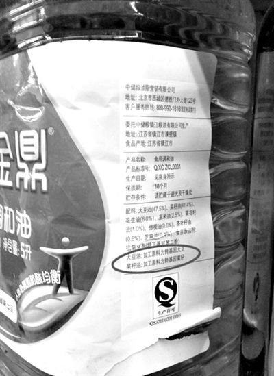 昨日，宣武门一超市内的两款调和油，均用小字标注转基因字样（圆圈内）。新京报记者邓琦摄