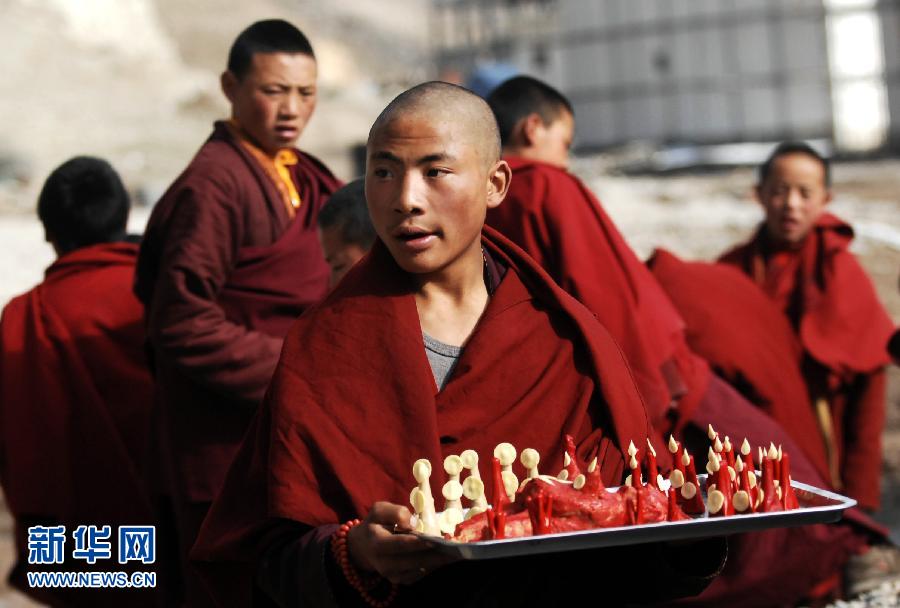 4月18日，僧人更尕东培在把贡品端往小经堂。新华社记者 王博 摄